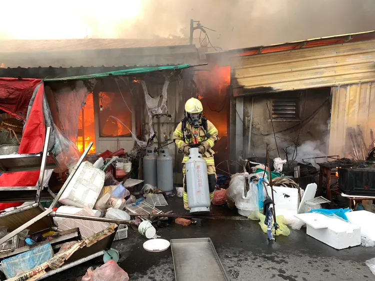 打火弟兄冒險搬出瓦斯桶，以防氣爆。讀者提供