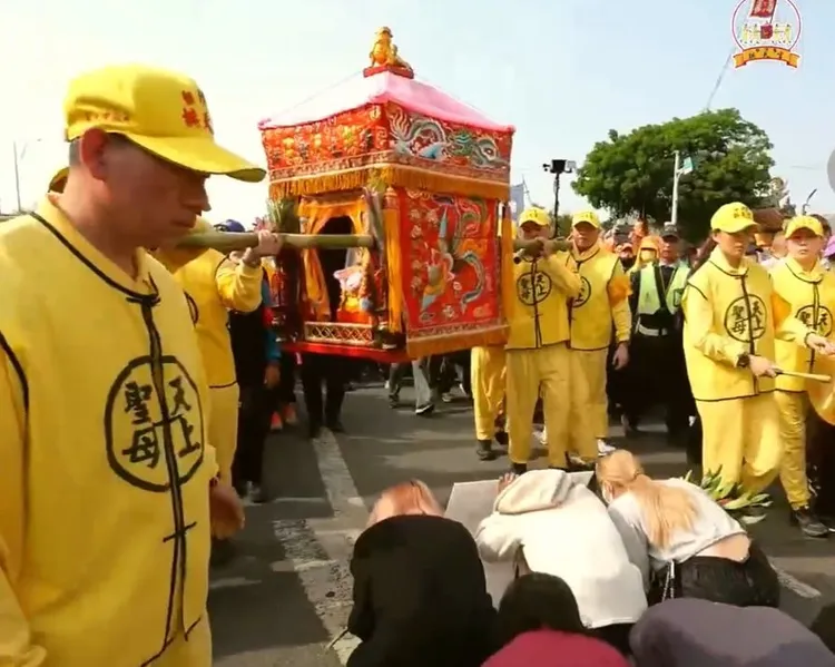 落水失蹤工人的3個姊姊，鑽轎底祈求白沙屯媽祖協助讓弟弟返家。翻攝白沙屯拱天宮臉書直播