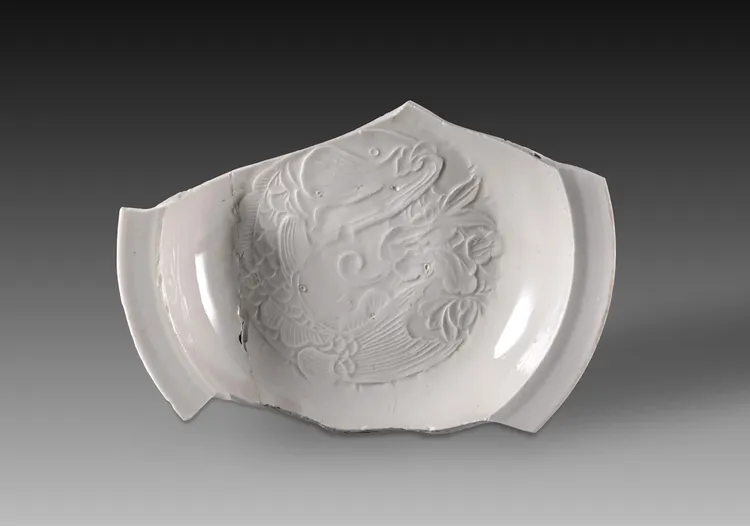 山西霍州陳村瓷窯址出土的元代細白瓷魚紋印花盤殘片。新華社