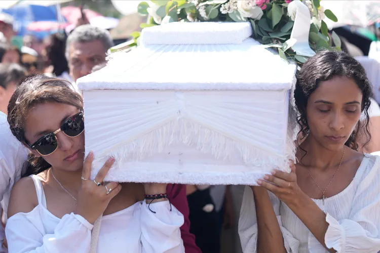 悲痛欲絕的女童親友為女童抬棺下葬。美聯社