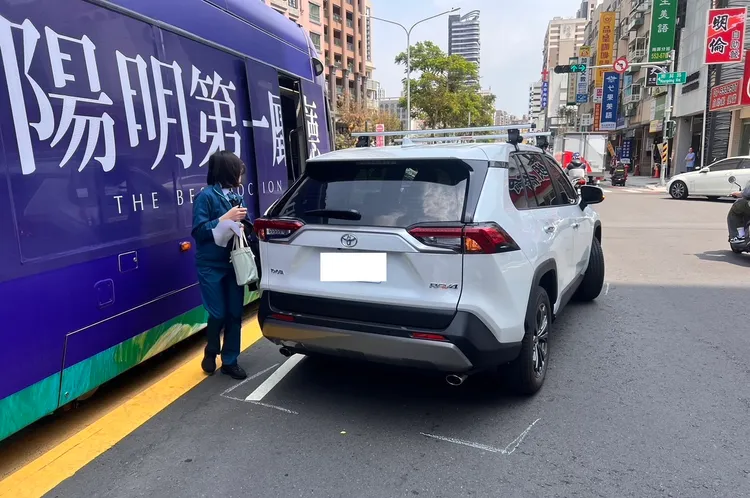 白色休旅車違規左轉撞輕軌，幸旅客受驚未受傷。讀者提供