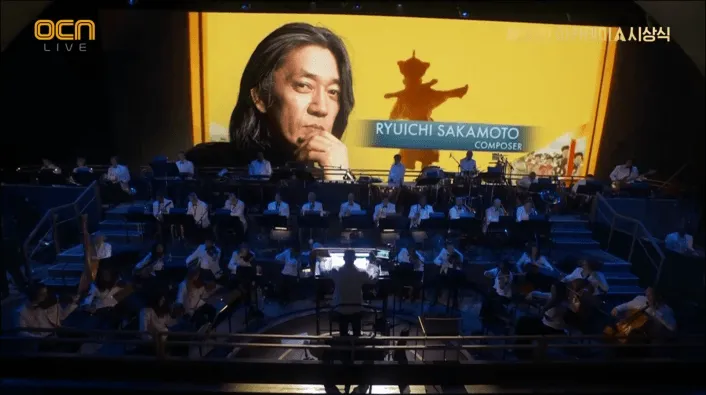 去年病逝的日本配樂大師坂本龍一也現身螢光幕。翻攝OCN