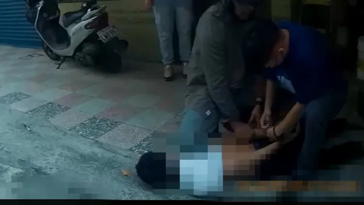 警方以警棍破窗，將嫌犯拖出車外壓制在地。翻攝畫面