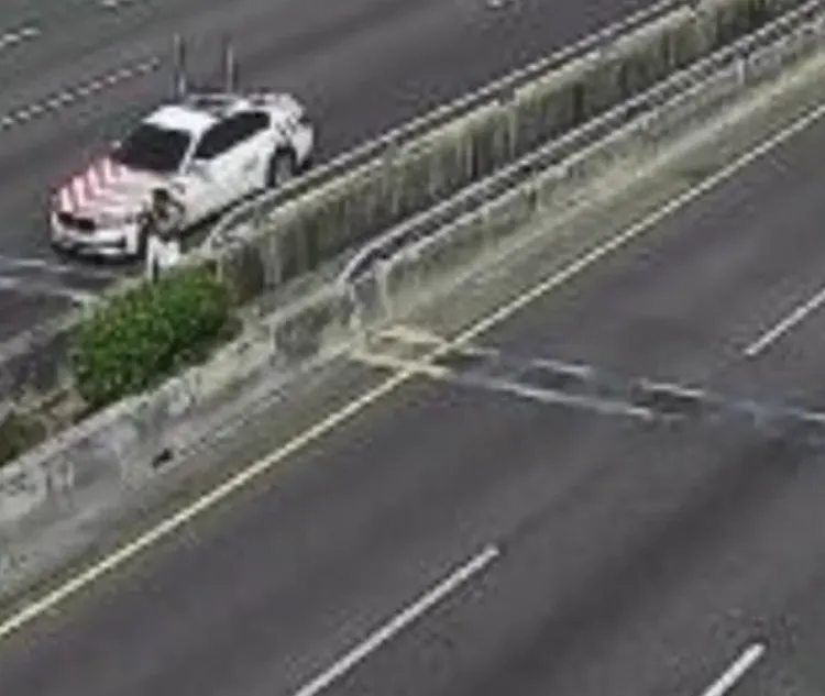 警方協助婦人跨過分隔島。讀者提供