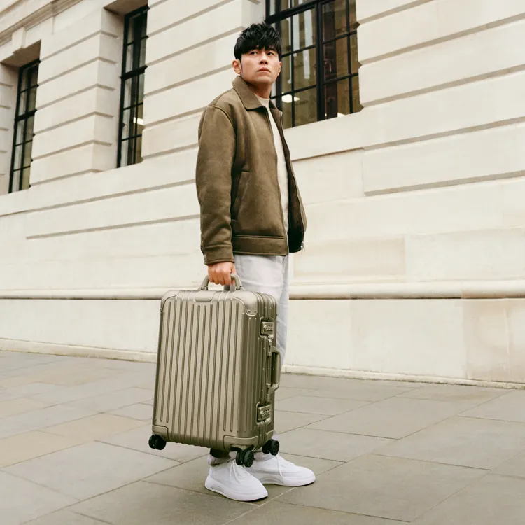 周杰倫拉上RIMOWA Original Cabin鈦金色行李箱漫步於倫敦街頭。品牌提供