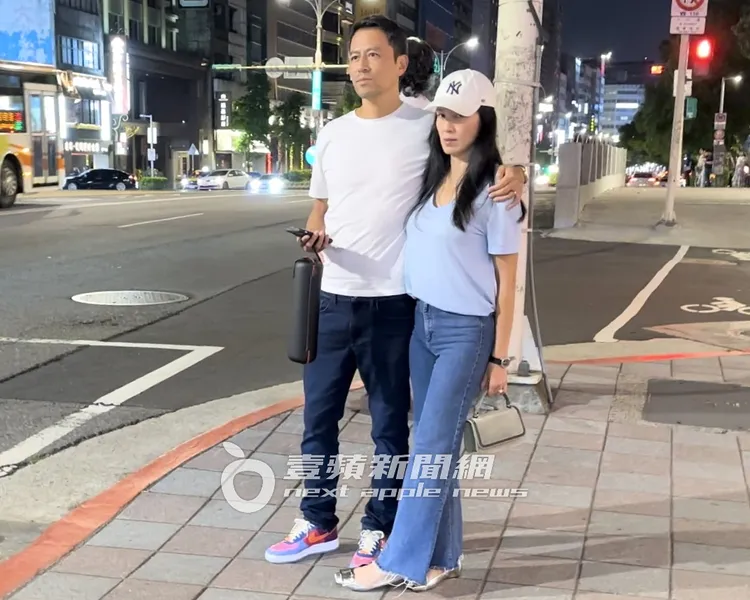 林熙蕾（右）手拿BRUNELLO CUClNELLl包，夫妻倆一起在路邊等多元計程車。特勤中心攝