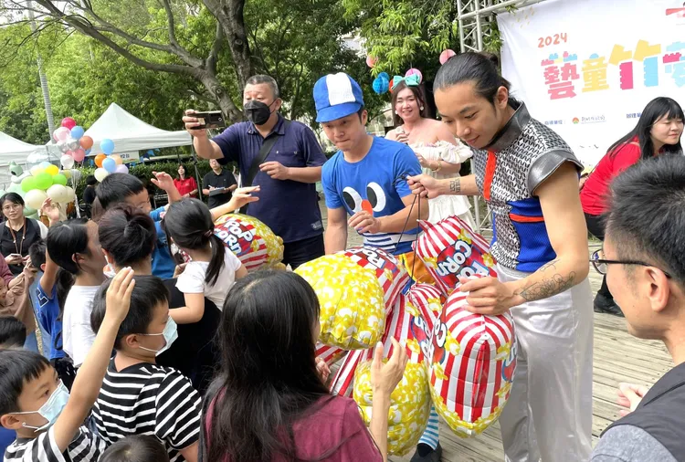 小朋友們爭相索取爆米花氣球。新竹縣府提供