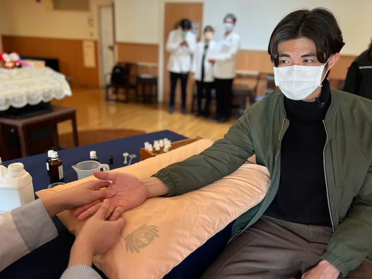 梁正群學手指關節精油按摩手法。大愛提供