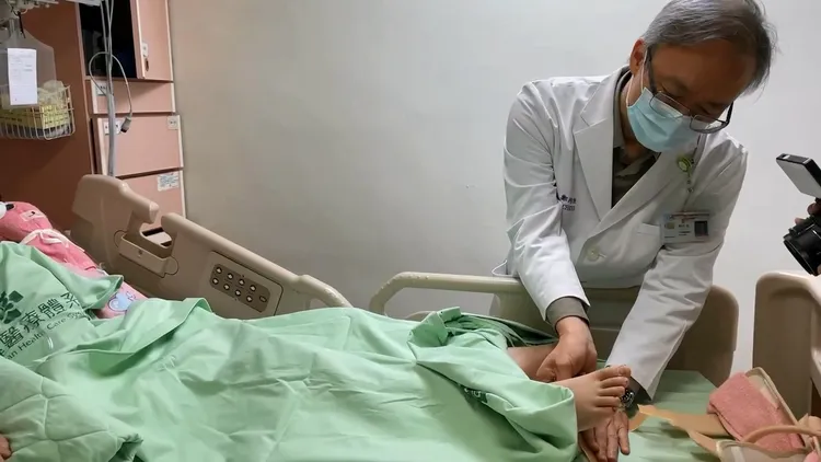 神經外科主任鄭均洹為陳家姊姊的下肢進行反應測試。彰化秀傳提供