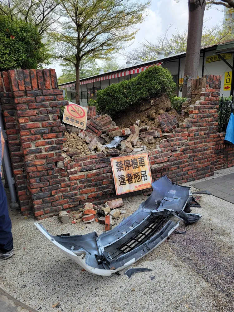 轎車保桿掉落，圍牆半毀崩落，顯見撞擊力之大。讀者提供