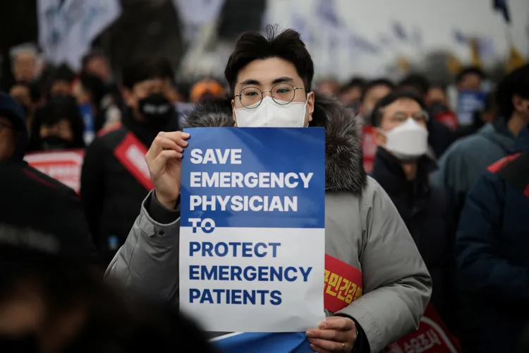 參加抗議的醫生手上標語寫著「救救急診醫生，才能保護急診病患」。路透社