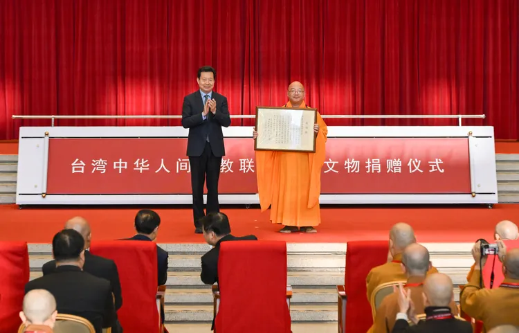 中國文化和旅遊部副部長、國家文物局局長李群（左）頒發感謝狀，右為中華人間佛教聯合總會主席、佛光山寺住持心保法師。新華社