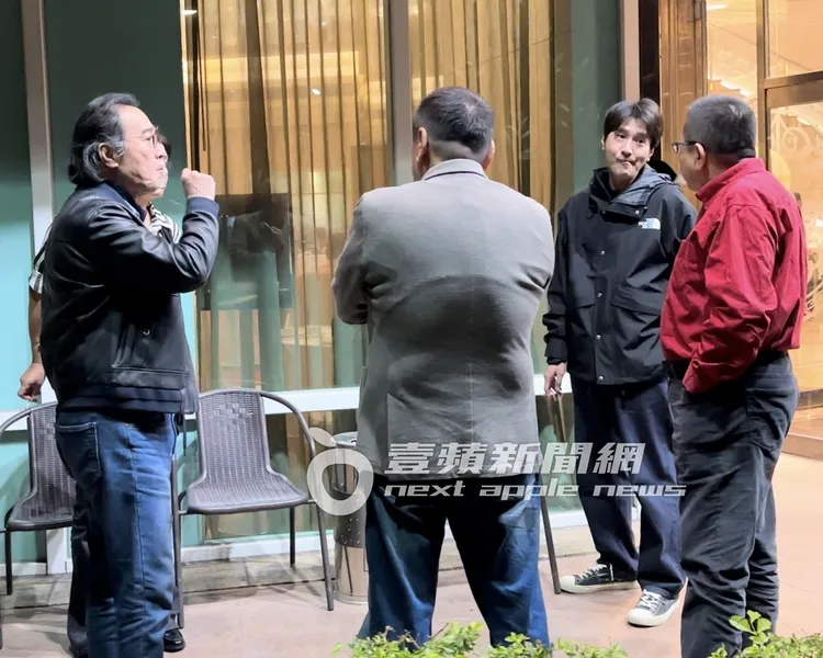 趙又廷（右二）叼著香菸和親友聊天。特勤中心攝