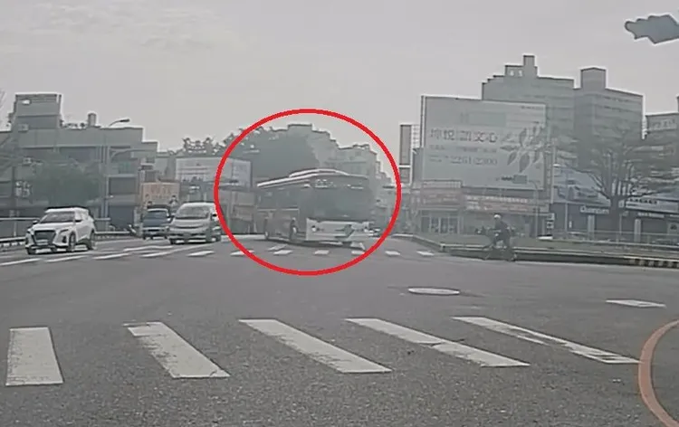 公車見前方將紅燈卻被車子擋住，竟「切西瓜」往左開進對向車道。讀者提供