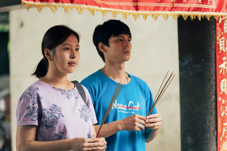 劉品言（左）與林柏宏姊弟拜拜算命求改運。伯樂影業提供