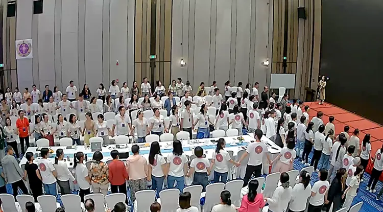 靈修集團現場，眾人穿著相同的制服喊口號。央視