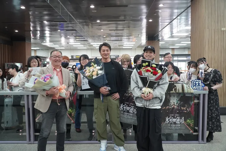 導演辻裕之（左起）、本宮泰風、黑羽麻璃央今天抵台，與松山機場接機的粉絲合影。希望影視行銷提供