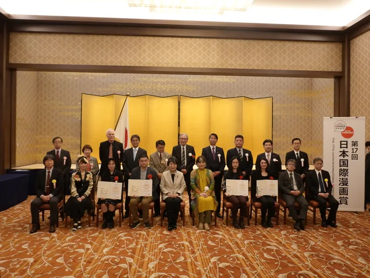 由日本外務省舉辦的第17屆日本國際漫畫賞5日晚間在東京舉頒獎典禮，台灣漫畫家簡嘉誠（前排左4）以作品「青空下的追風少年」獲最優秀獎（金獎），日本外務大臣上川陽子（前排左5）坐在他身旁。中央社
