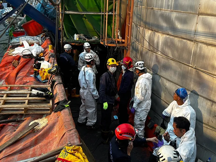 消防人員著防護衣從人孔入槽搶救。高市消防局提供