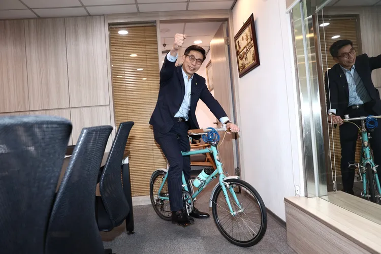 鍾佳濱平日有運動習慣，應記者要求直接在辦公室「開騎」。彭欣偉攝
