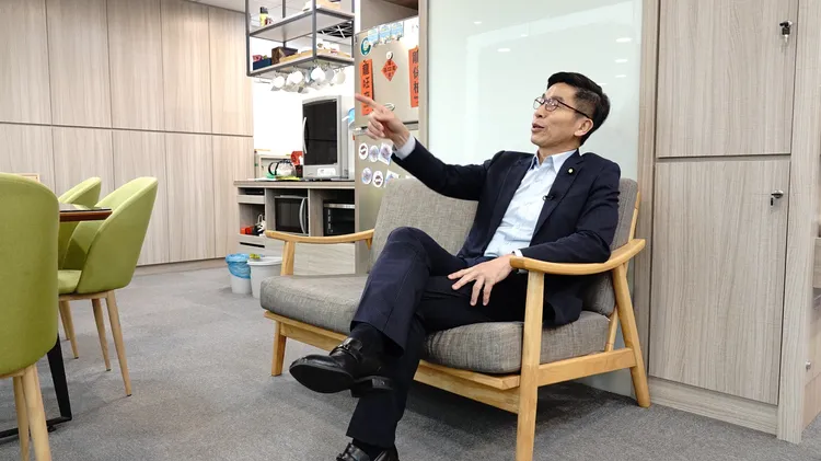 鍾佳濱講解坐在沙發上看見窗外的景色。彭欣偉攝