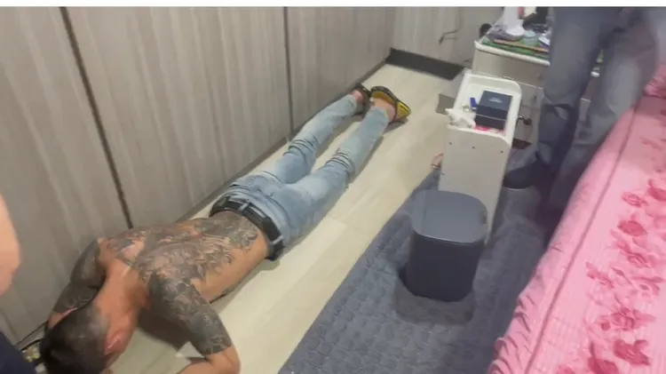 蕭姓嫌犯在床邊抱頭被逮。翻攝畫面