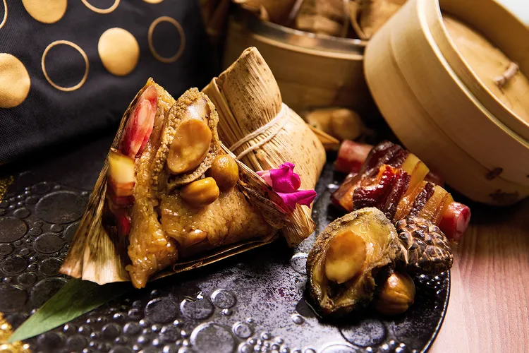 「松露鮑魚臘味粽」以精選整顆鮑魚和雲林快樂豬肉為主要食材，經過繁複烹調後再入餡，天然油脂自然透入晶透的長糯米有著彈牙鮮嫩的口感。業者提供