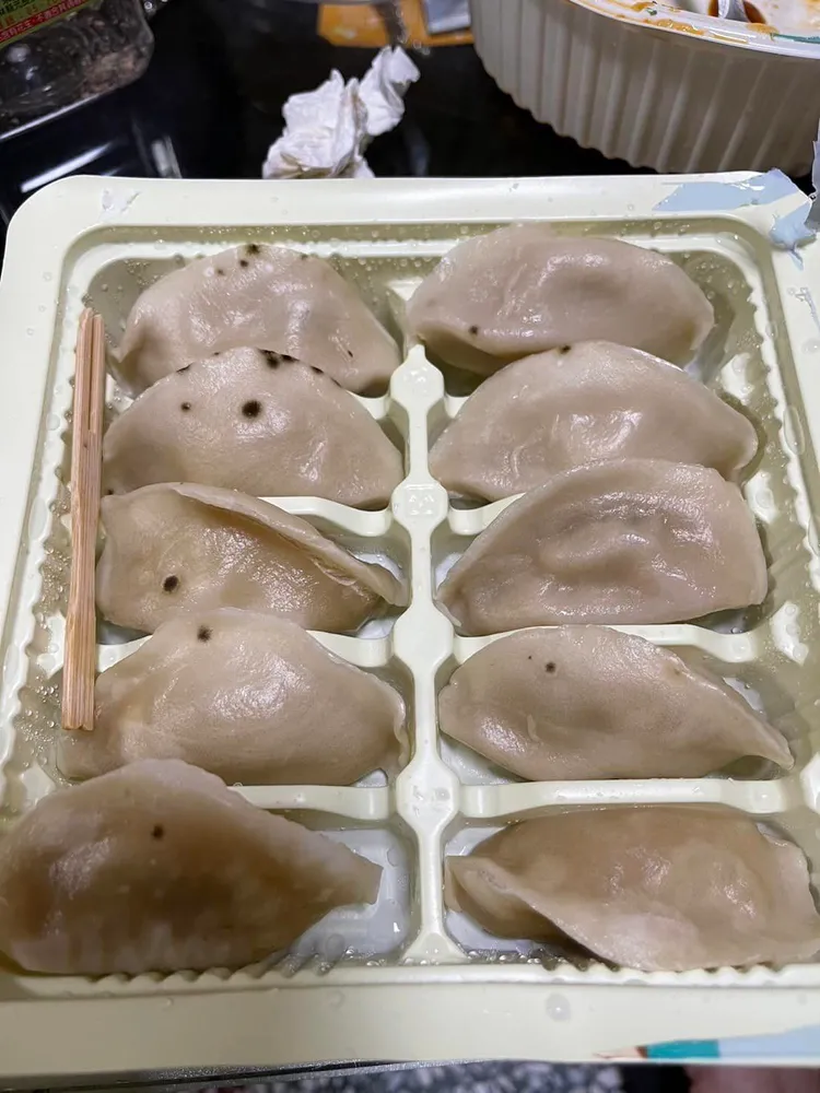 網友打開第二盒超商微波水餃，一樣是佈滿黑點。翻攝「爆料公社」