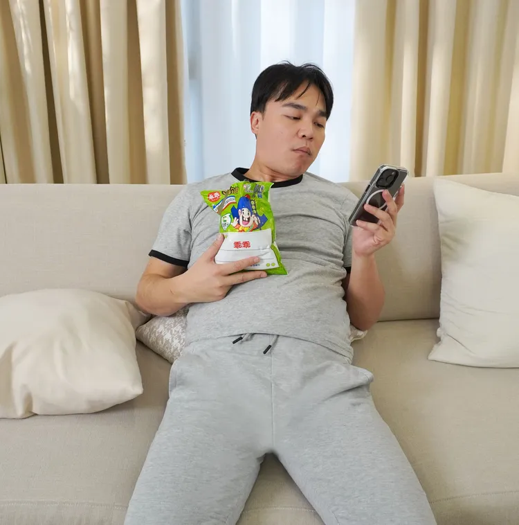 李亮瑾出賣張峰奇躺在沙發上挺著肥油肚吃零食的爆肉崩壞照。CHOYeR曲易提供