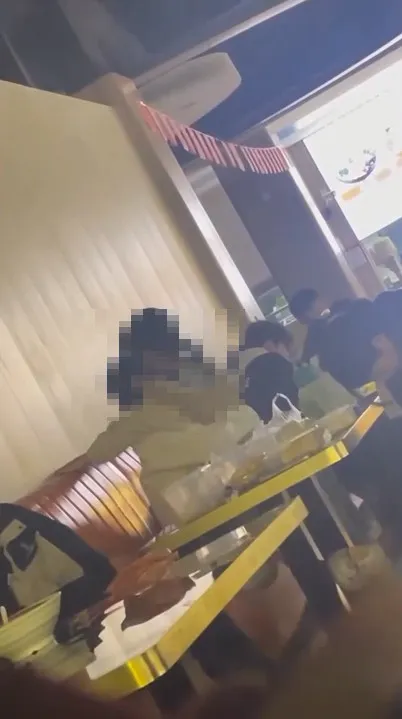 一段年輕男女，在餐廳座椅上交疊，還上下抖動的影片。翻攝《●【爆廢公社二館】●》社團