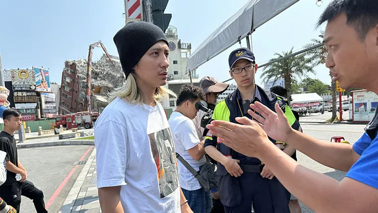 有愛貓人士到場要求雲梯車送誘捕籠而與里長張東耀（右）發生口角。中央社