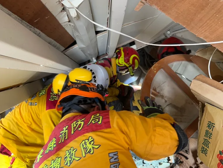 特搜人員挺進傾斜的建物內搜尋失聯婦人。翻攝畫面