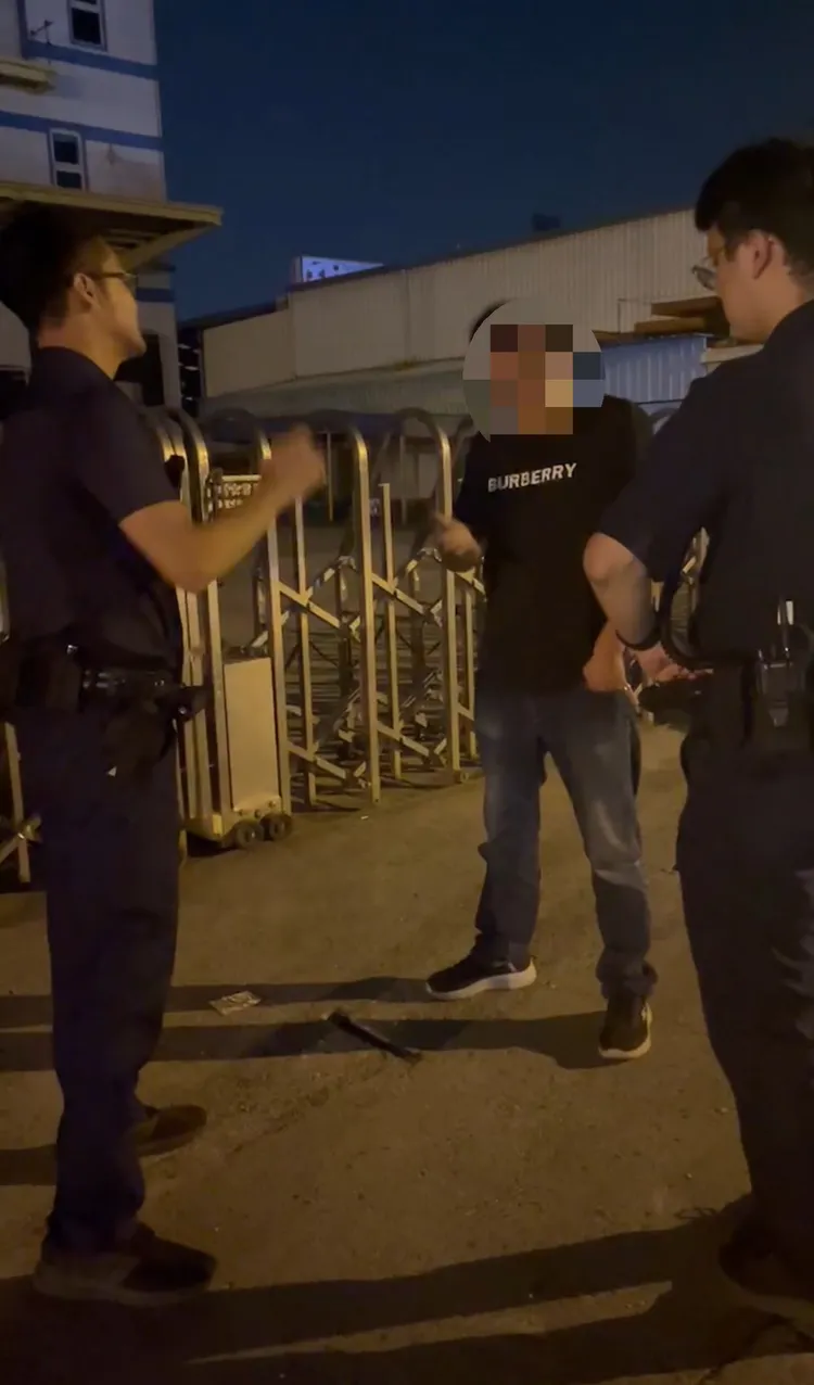 黃先生(中)在廠房門口與2員警據理力爭，質疑為何不抓現行犯。黃先生提供