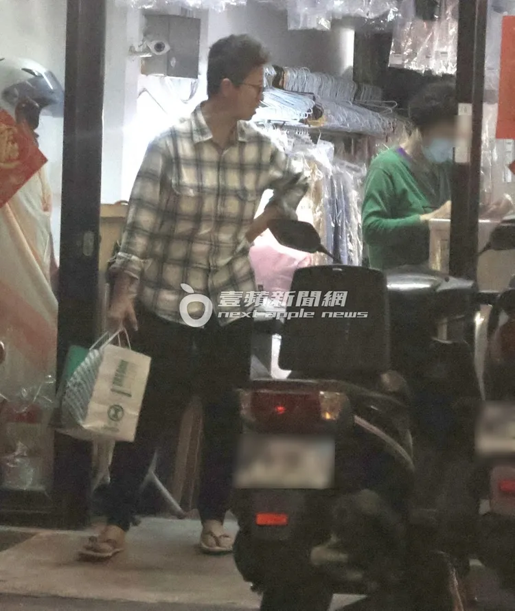 司機提著衣服離開洗衣店，跟洗衣店老闆聊得十分熱絡。特勤中心攝