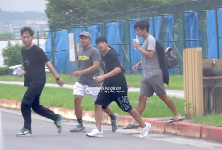 周杰倫（右二）在司機及陪打小弟們的護送下走出網球場。特勤中心攝