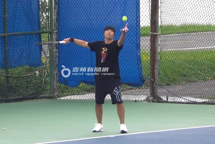 周杰倫展開雙臂，將網球往上拋，準備猛烈的發球。特勤中心攝