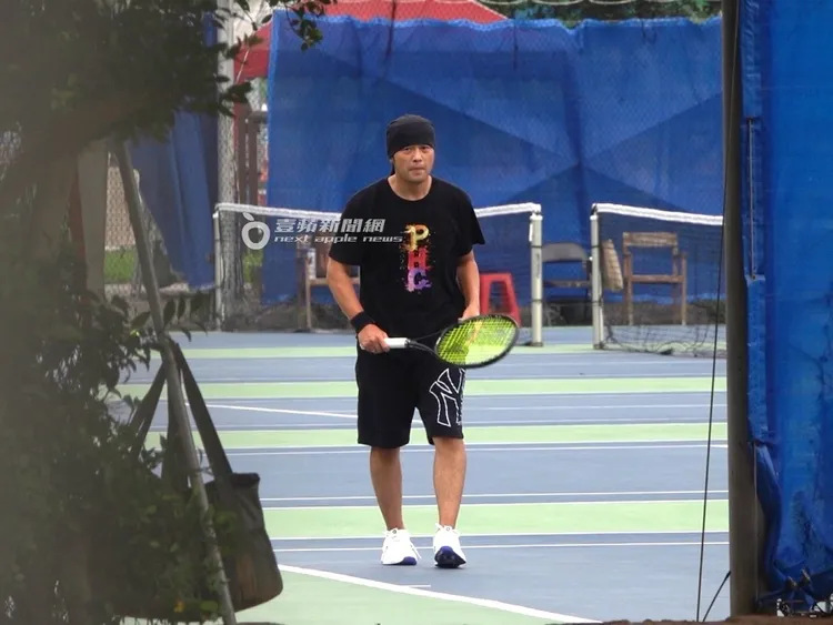 周杰倫走回發球線，握著網球拍邊思考著剛才動作哪裡需要改進。特勤中心攝