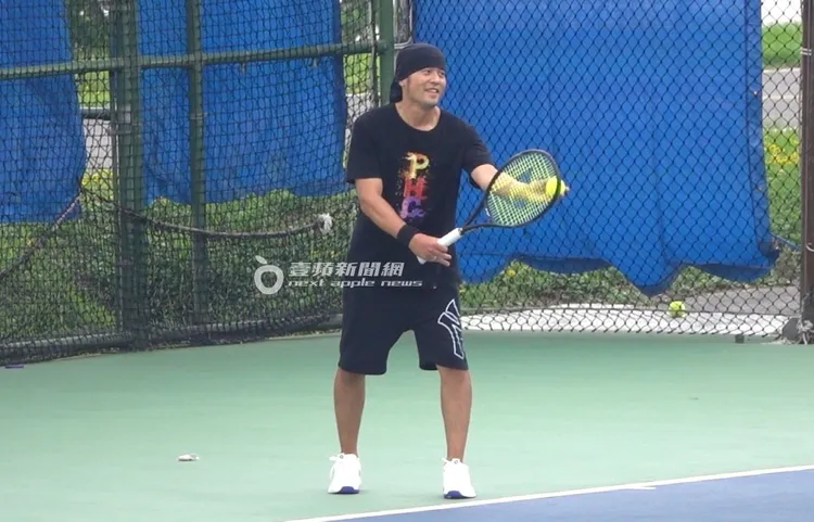 周杰倫一手拿著網球拍，一手拿著網球準備練習發球。特勤中心攝