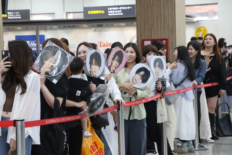 很多粉絲拿著龜梨和也的扇子接機。攝影中心攝