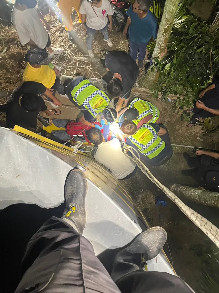 眾人聯手將昏迷老農拖到塔外，送醫急救。警消提供