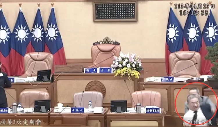 蔣根煌脫掉西裝外套，走下台準備找陳明義幹架。議員提供