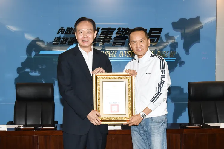 刑事局長周幼偉（左）回贈感謝狀給予愛爾麗總裁常如山（右）。刑事局提供