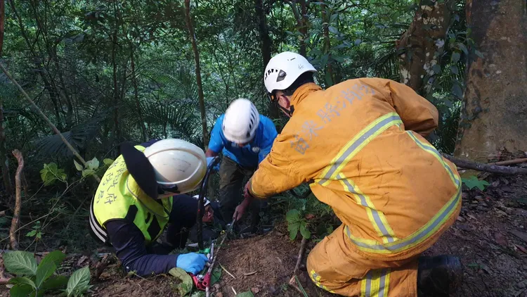 休旅車滑落山谷，消防人員拉繩索救援。民眾提供