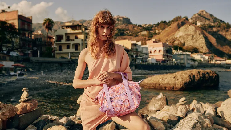 Kipling全新粉橘印花系列包款展現「輕時尚」風格。業者提供