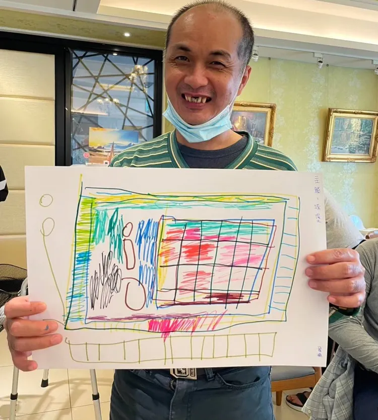 阿源於照顧中心展示畫畫作品。翻攝畫面