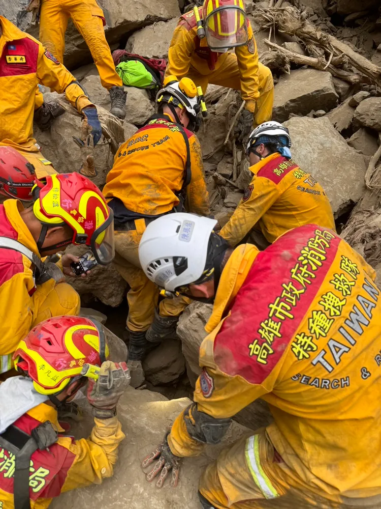 特搜人員開挖落石，試圖拉出罹難者。高雄特搜提供