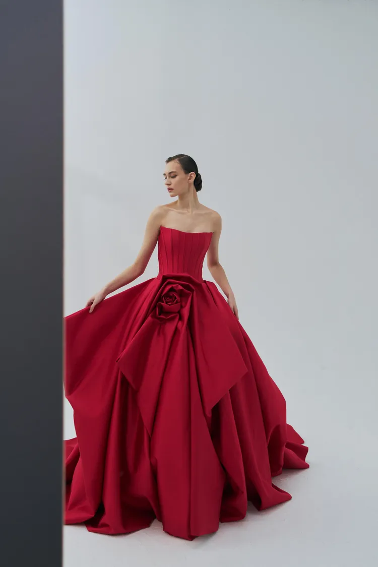 薔薇紅色緞面晚禮服，使用明豔亮紅絲毛緞布做整件立體剪裁結構。品牌提供