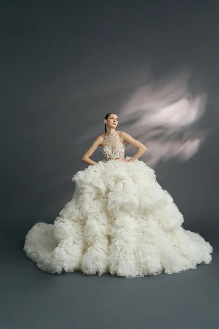 槴子花亮片削肩白紗，使用歐洲進口折射水晶片面料及層次荷葉堆疊裙襬呈現。品牌提供