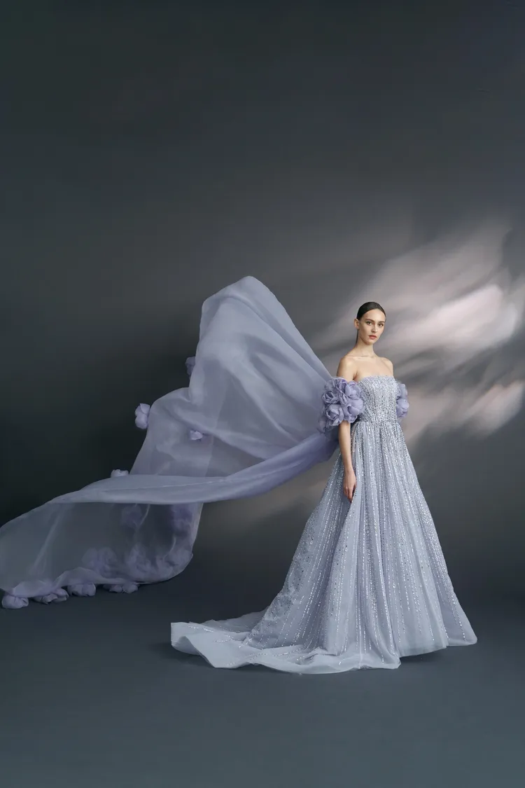 紫丁香紫藍煙霧色晚禮服，使用銀色裸縫珠條，並搭配手工燒製花片外罩。品牌提供