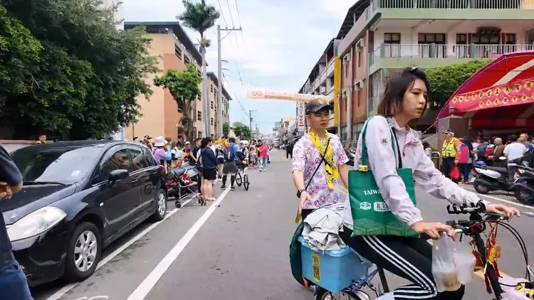 張皓文與女友騎1輛自行車參加大甲媽遶境，為開刀的父親還願。大甲媽祖教師研習團提供